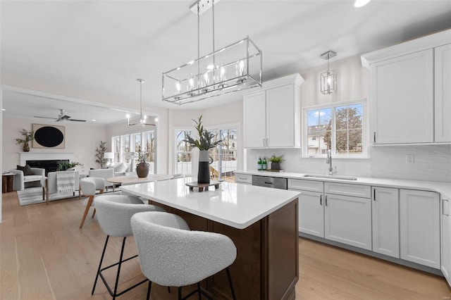 kitchen featuring a center island, a fireplace, a breakfast bar area, backsplash, and a sink