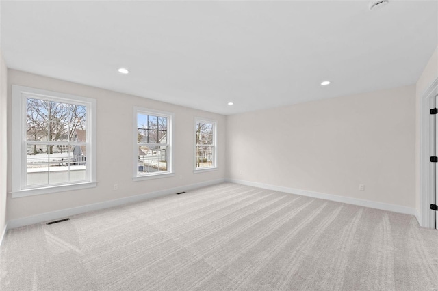 spare room with recessed lighting, baseboards, and light colored carpet