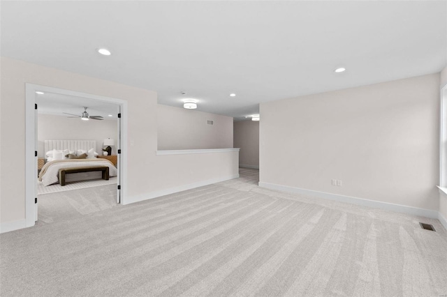 below grade area with recessed lighting, light colored carpet, a ceiling fan, baseboards, and visible vents