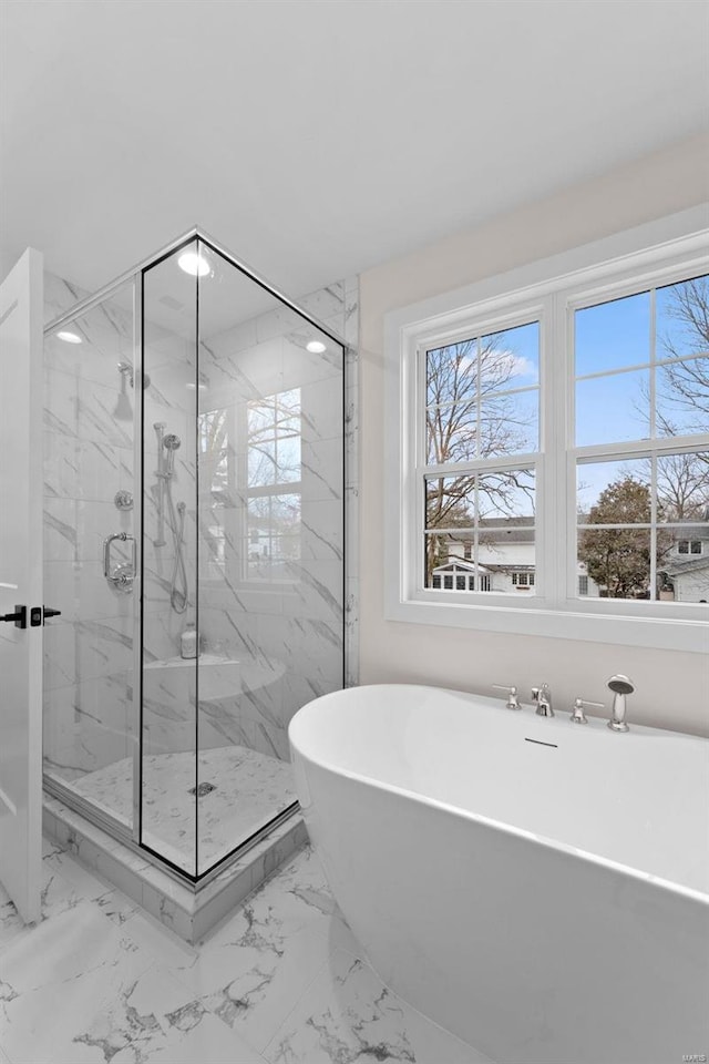 bathroom with marble finish floor, a soaking tub, and a marble finish shower