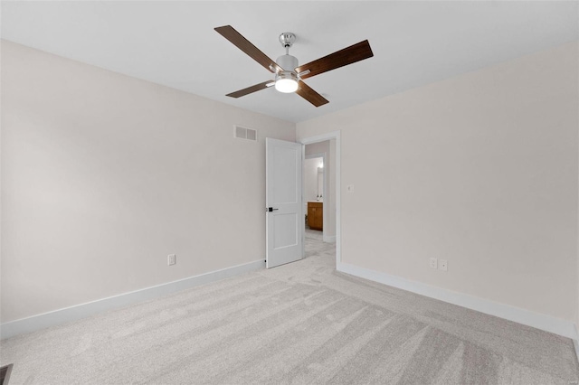 unfurnished room featuring a ceiling fan, light colored carpet, visible vents, and baseboards