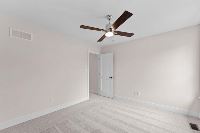 empty room with light colored carpet, visible vents, and baseboards