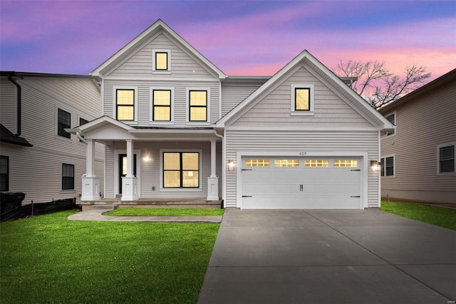 view of front facade with a garage, covered porch, driveway, and a lawn