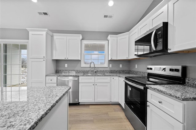 kitchen featuring light wood finished floors, visible vents, white cabinets, appliances with stainless steel finishes, and a sink