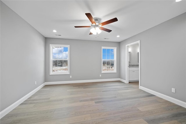 empty room with recessed lighting, light wood-type flooring, a ceiling fan, and baseboards