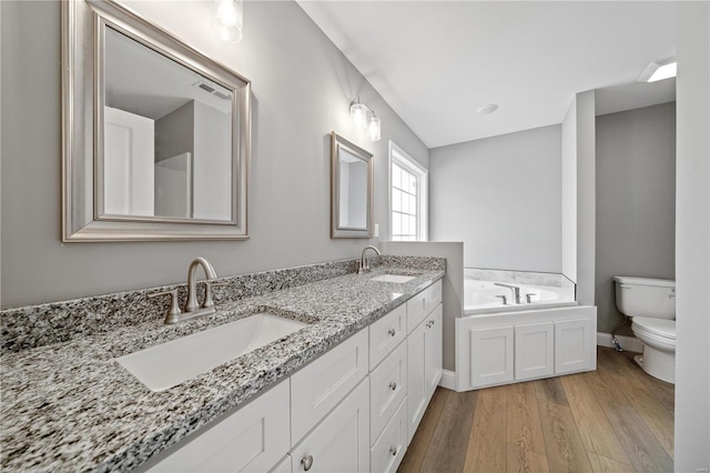 full bath with a garden tub, visible vents, a sink, and wood finished floors