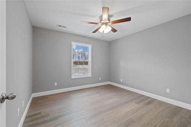 unfurnished room featuring baseboards, ceiling fan, visible vents, and light wood-style floors