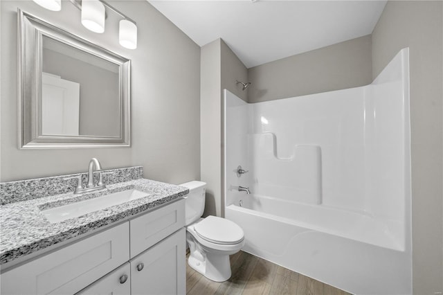 bathroom with toilet, bathtub / shower combination, wood finished floors, and vanity