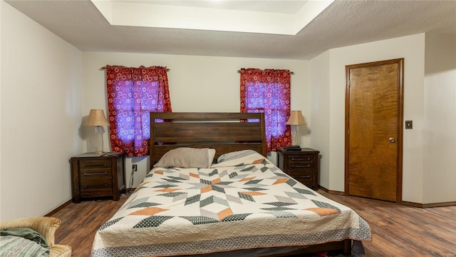 bedroom featuring dark hardwood / wood-style flooring and a textured ceiling