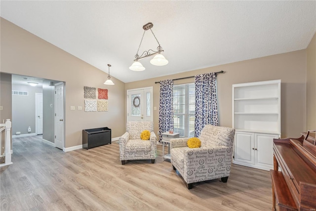 sitting room with vaulted ceiling and light hardwood / wood-style floors