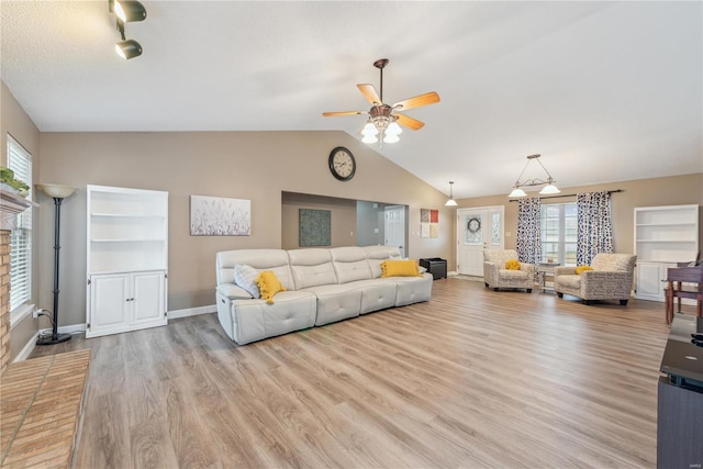 living room with ceiling fan, lofted ceiling, and light hardwood / wood-style flooring