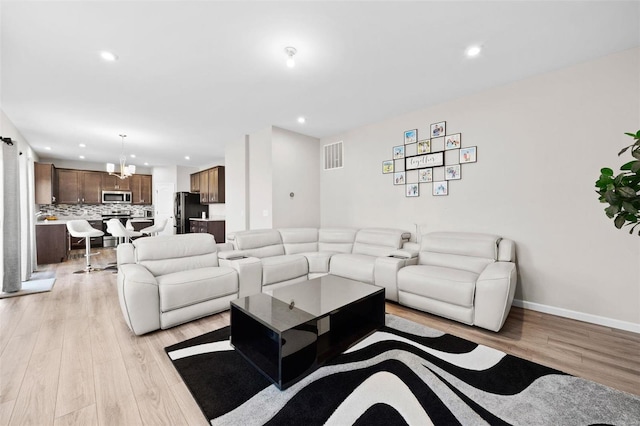 living room with recessed lighting, a notable chandelier, light wood-style floors, and visible vents