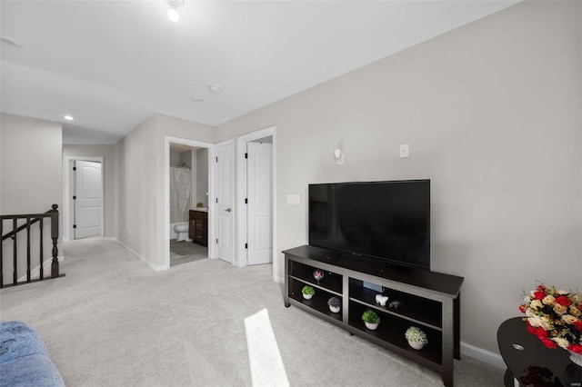 carpeted living area featuring baseboards