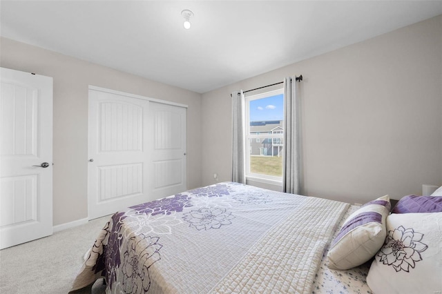 carpeted bedroom with a closet and baseboards