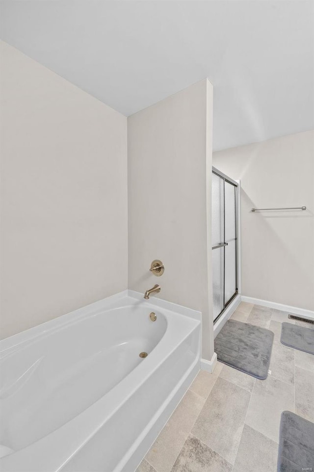 bathroom featuring a garden tub, visible vents, a stall shower, and baseboards