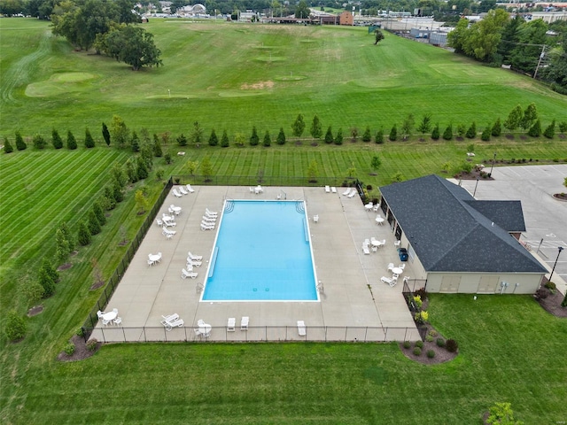 view of swimming pool featuring a yard and fence