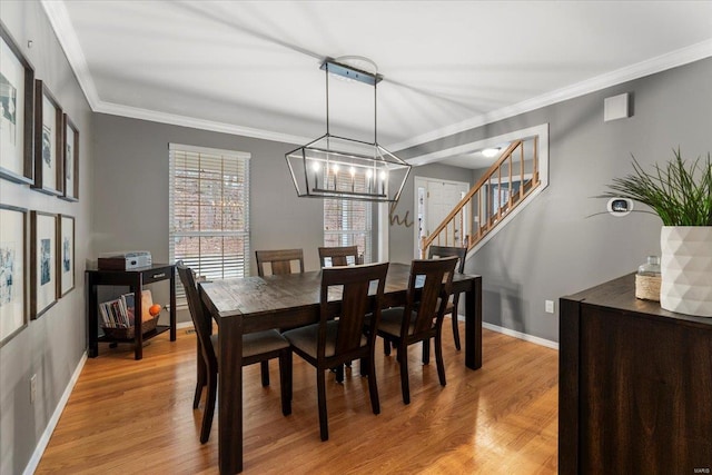 dining space with stairway, baseboards, crown molding, and light wood-style floors