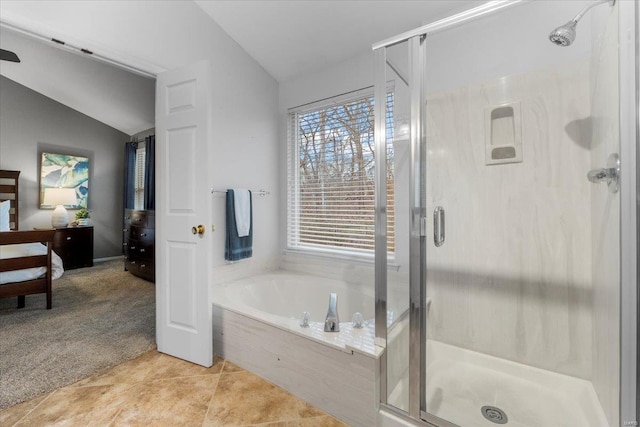 bathroom featuring tile patterned flooring, lofted ceiling, a garden tub, and a stall shower