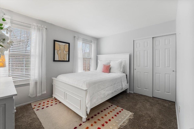 bedroom with a closet, light colored carpet, and baseboards