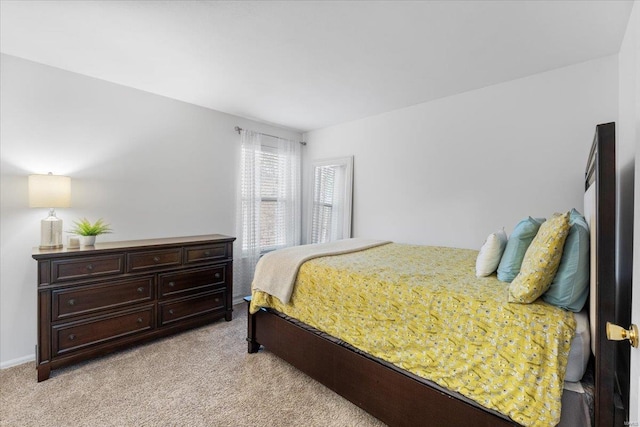 bedroom featuring light carpet and baseboards