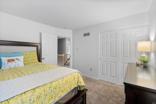 bedroom with visible vents, carpet floors, baseboards, and a closet