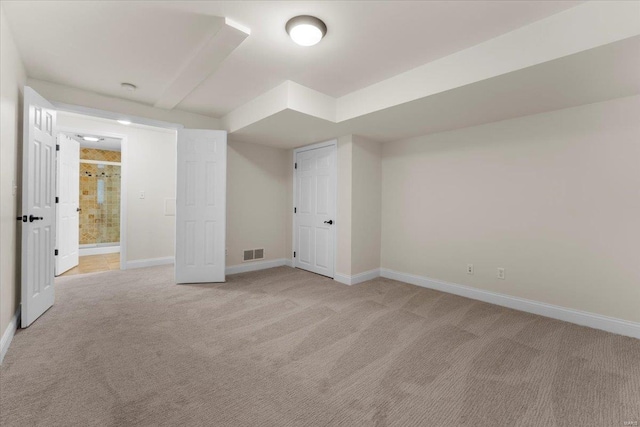 interior space featuring visible vents, light colored carpet, and baseboards