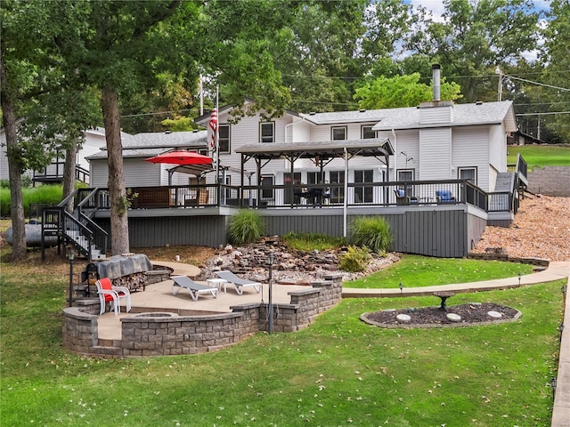 back of house with a deck, a yard, an outdoor fire pit, and a patio area