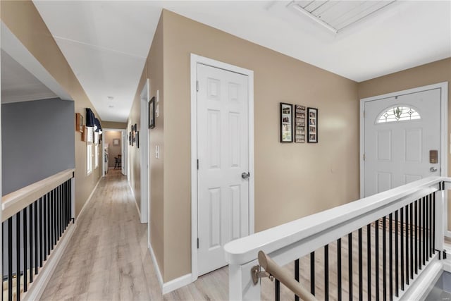 hallway featuring an upstairs landing, light wood-style flooring, and baseboards