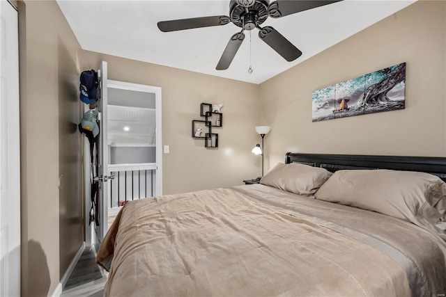 bedroom with ceiling fan, wood finished floors, and baseboards