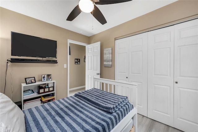 bedroom featuring a ceiling fan, a closet, and light wood finished floors