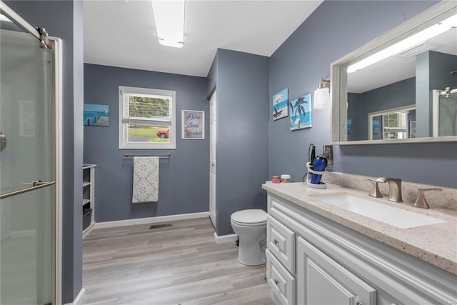 full bath featuring toilet, wood finished floors, visible vents, baseboards, and an enclosed shower