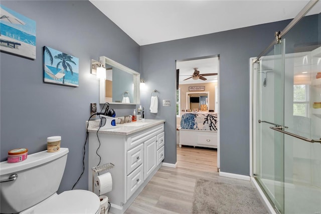 bathroom with vanity, a shower stall, toilet, and wood finished floors