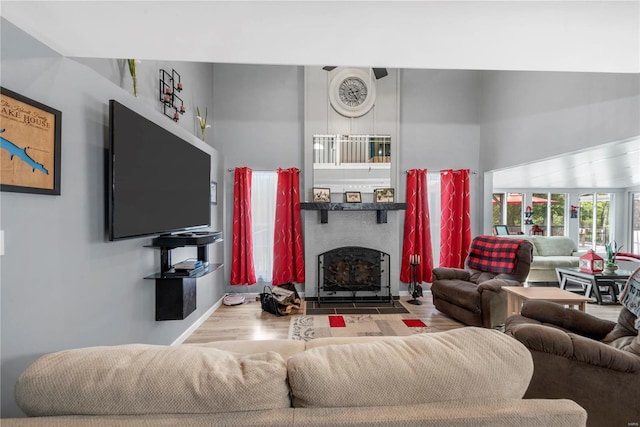 living area featuring wood finished floors and a fireplace with flush hearth
