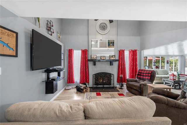 living room with a fireplace with flush hearth and wood finished floors