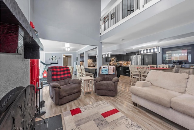 living room with a towering ceiling and wood finished floors