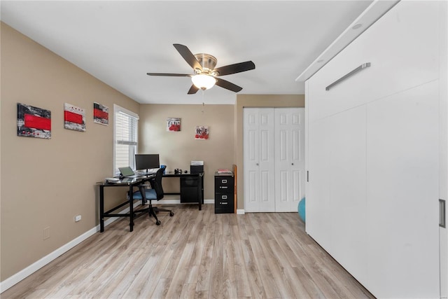 office featuring light wood-type flooring, a ceiling fan, and baseboards