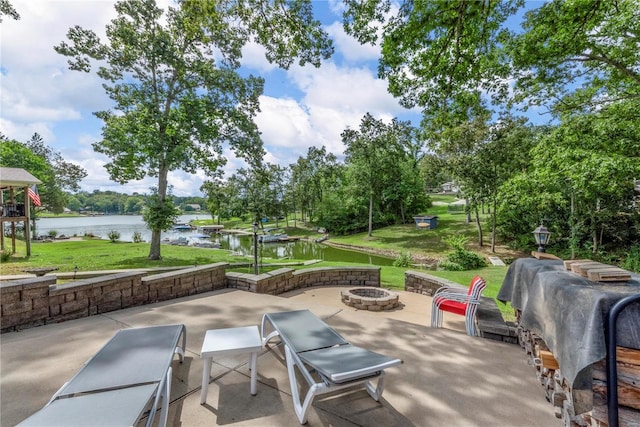 view of patio / terrace with an outdoor fire pit and a water view
