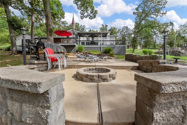 view of patio with an outdoor fire pit and a wooden deck