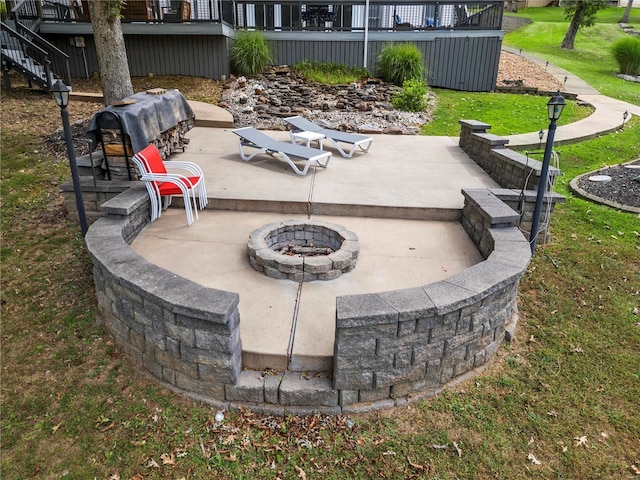 view of patio / terrace featuring an outdoor fire pit, stairs, and a deck