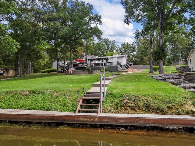 exterior space featuring stairs and a deck with water view