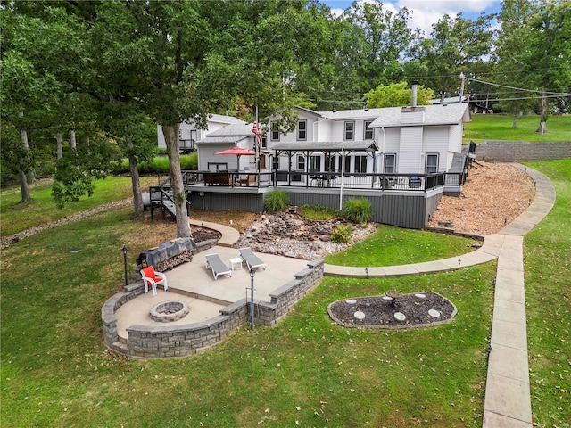 rear view of property with a yard, an outdoor fire pit, a patio area, and a wooden deck