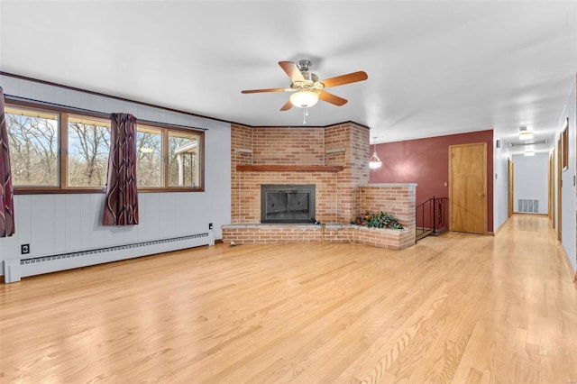 unfurnished living room with baseboard heating, ceiling fan, a fireplace, and light hardwood / wood-style flooring