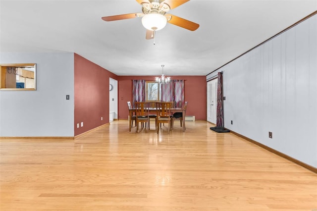 dining area with a baseboard heating unit, ceiling fan with notable chandelier, and light hardwood / wood-style floors