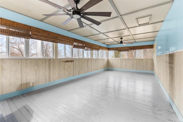 unfurnished sunroom featuring ceiling fan and a healthy amount of sunlight