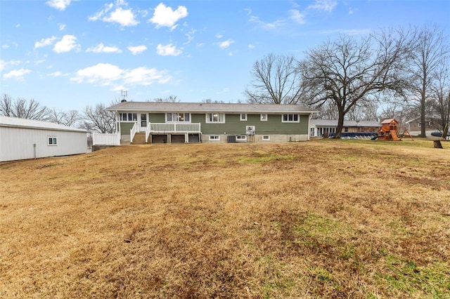 rear view of property featuring a lawn and a playground