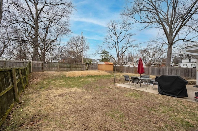 view of yard featuring a patio, an outbuilding, a fenced backyard, and a shed