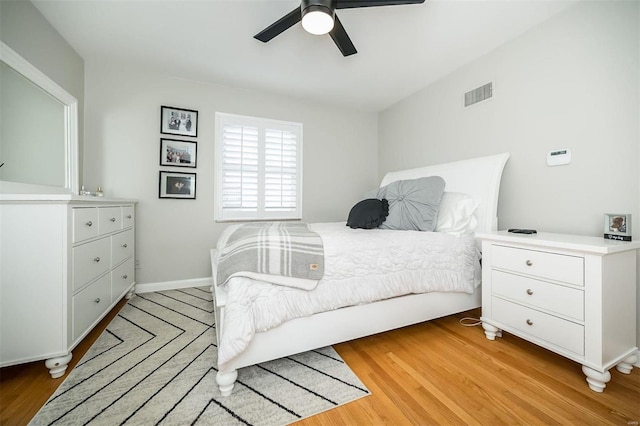 bedroom with visible vents, baseboards, light wood-type flooring, and a ceiling fan