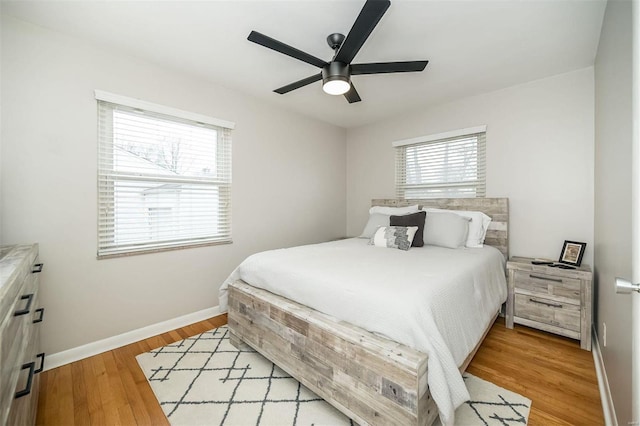 bedroom featuring light wood finished floors, ceiling fan, and baseboards