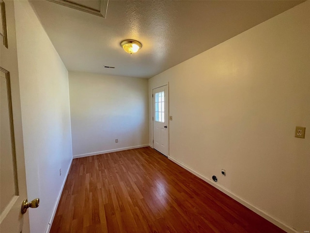 unfurnished room with hardwood / wood-style floors and a textured ceiling