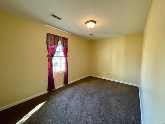 unfurnished room featuring dark carpet